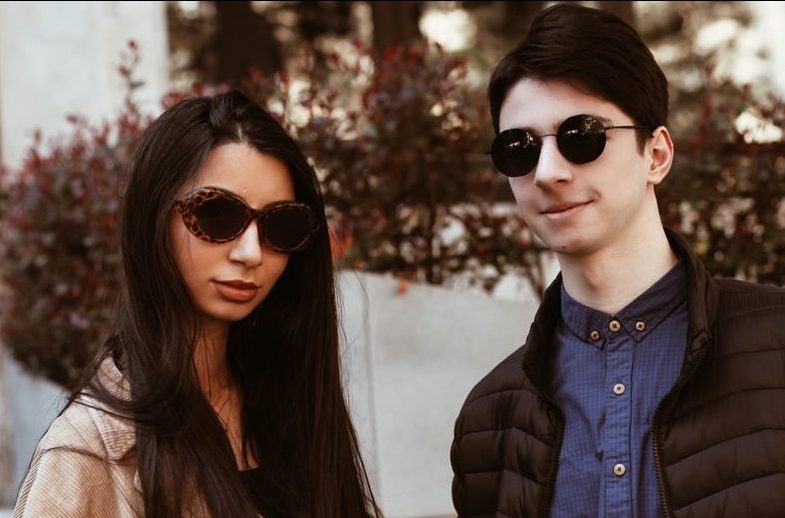 woman in black sunglasses and brown coat