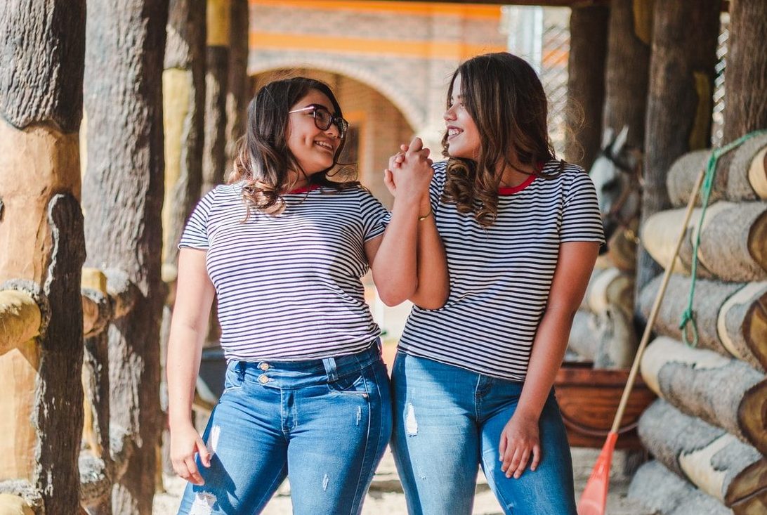 two smiling women while holding their hands at daytime